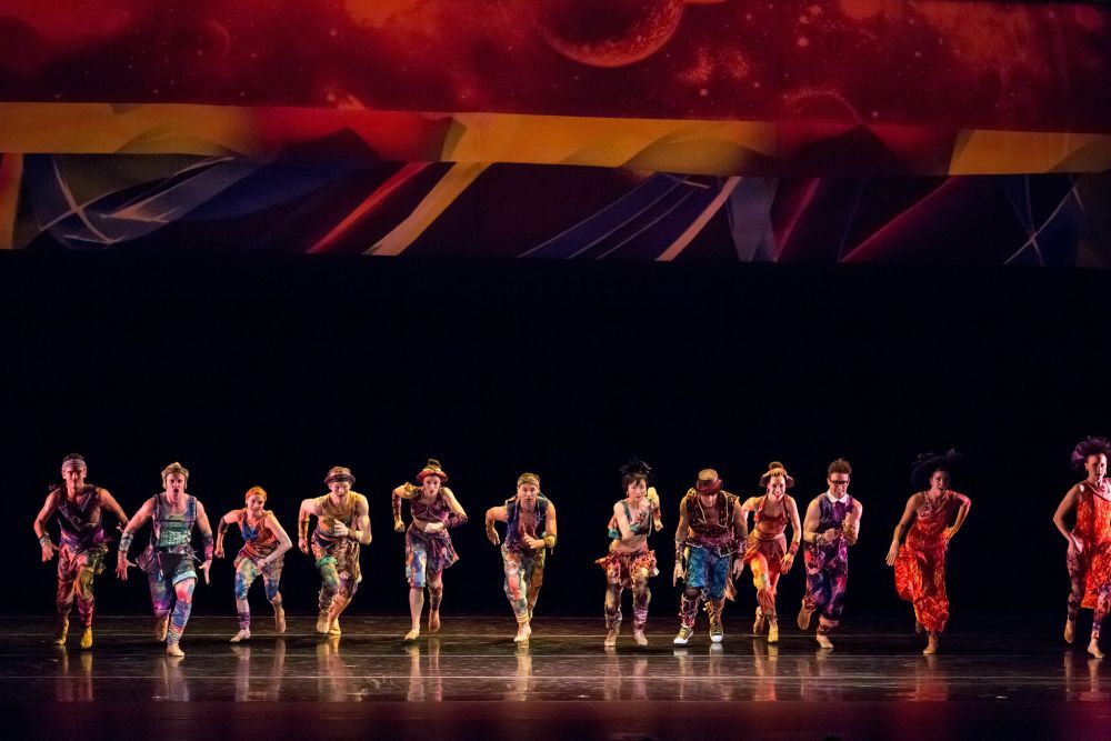 A group of dancers on stage mid-performance.