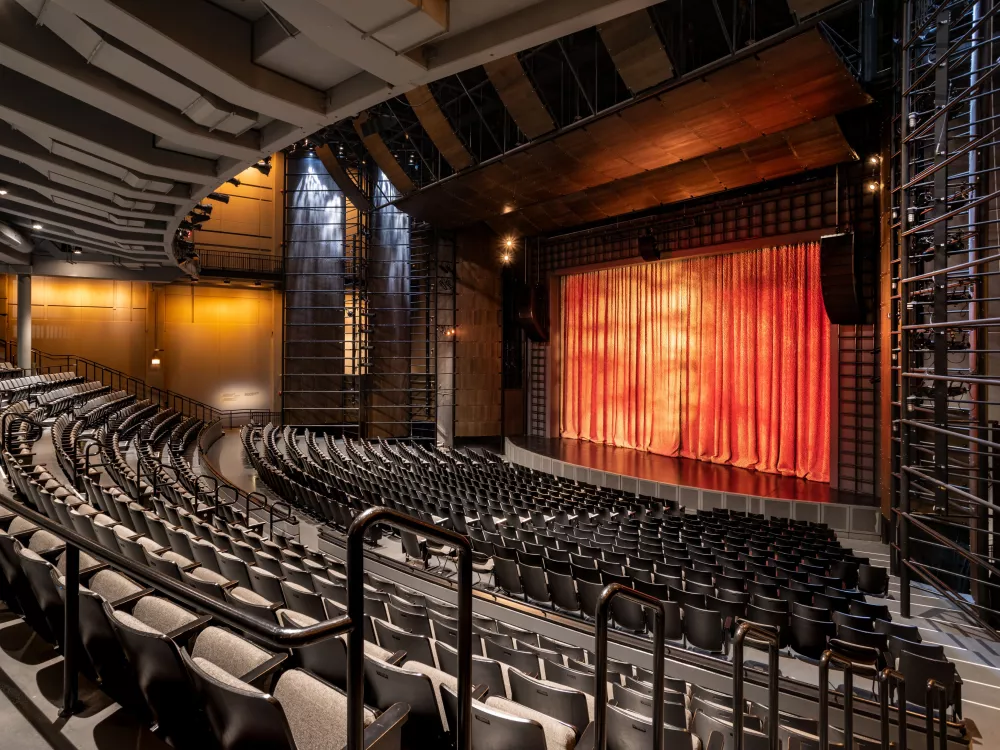 Image of an empty auditorium with a red curtain 