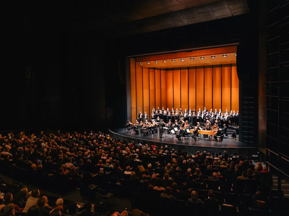 Image of a full auditorium watching an orchestra on stage
