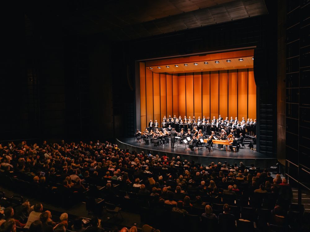 Image of a full auditorium watching an orchestra on stage