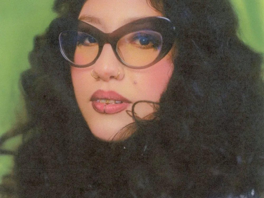 Sparkmami wearing glasses. She has curly hair.