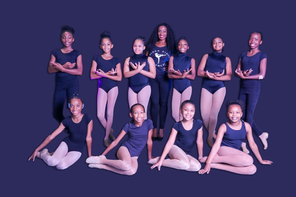 The young dancers stand together with pride and confidence, their poses reflecting their dedication and the precision of their training. 