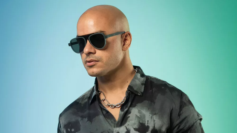 A man posing and wearing sunglasses.