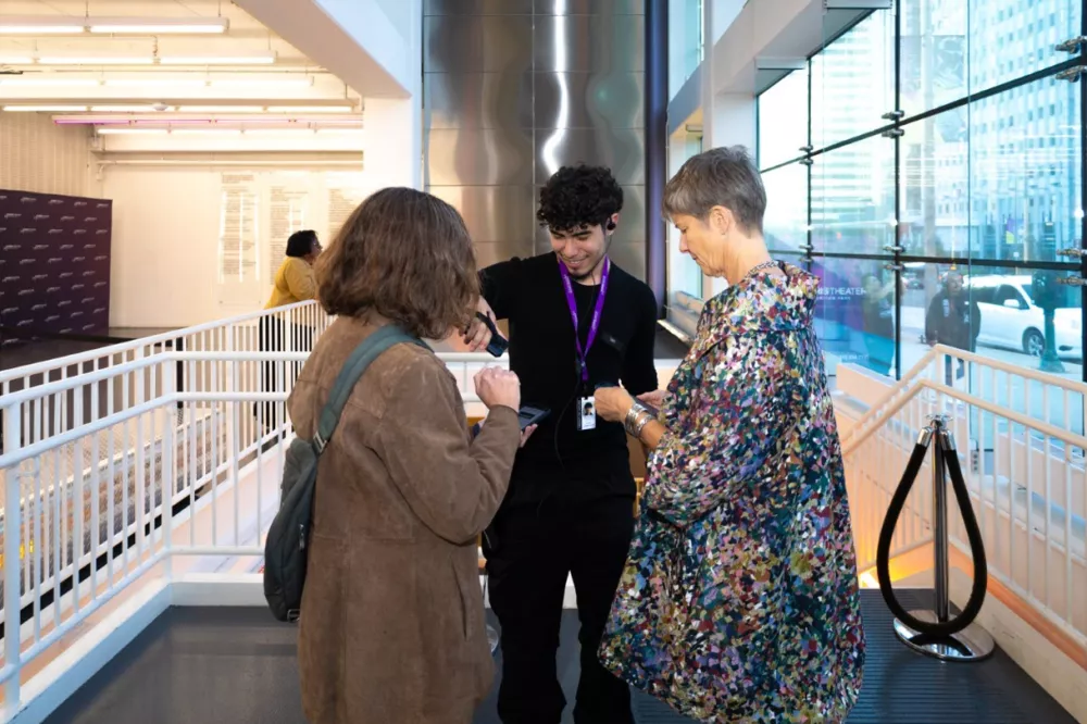 An Audience Service Representative scanning a patron's ticket on their phone.