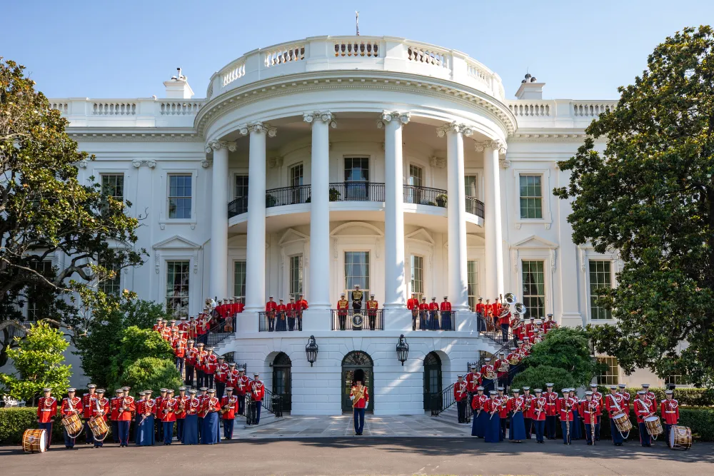 The United States Marine Band posing in front of the White House.