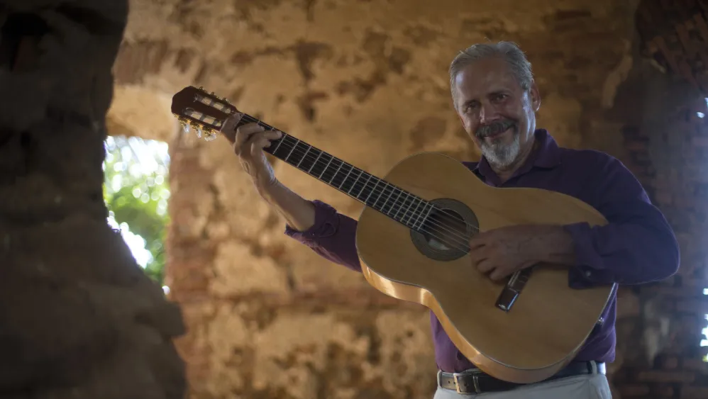 A man holding a guitar. 