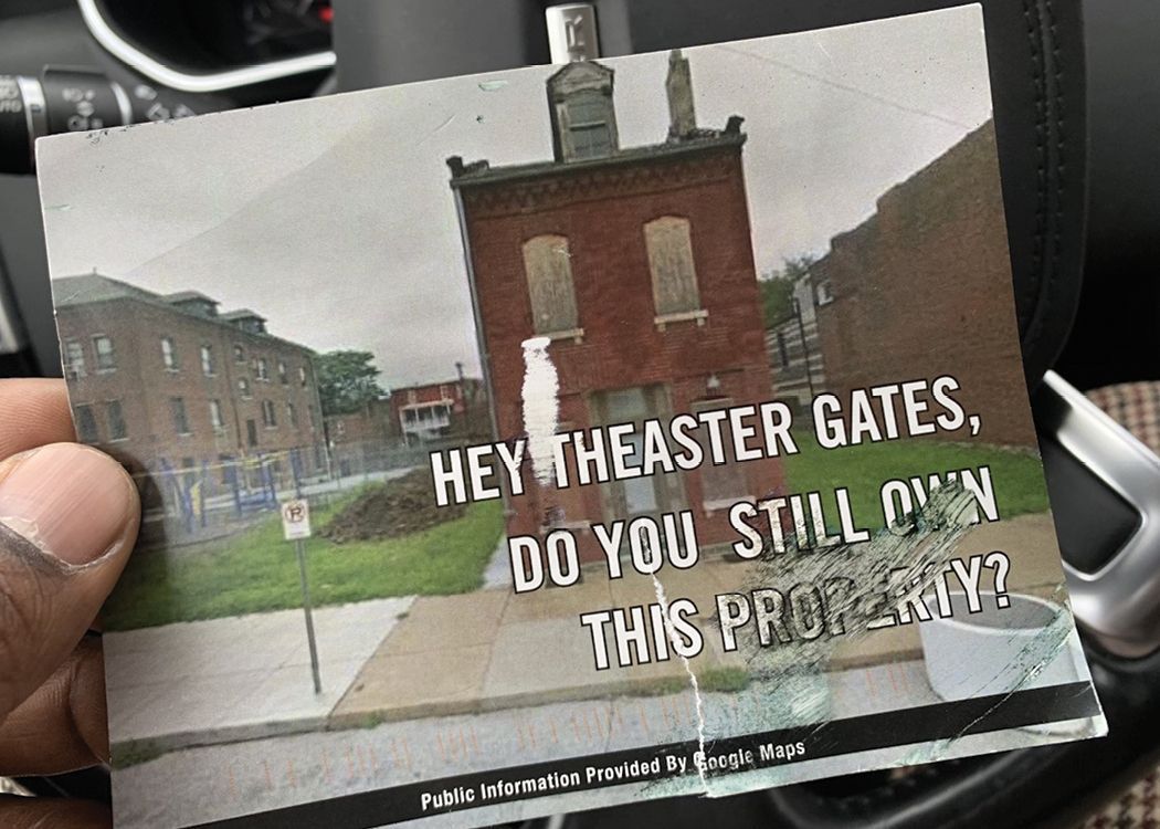 Someone's hand is holding a picture of a building with text "Hey Theaster Gates, Do you still own this property?"