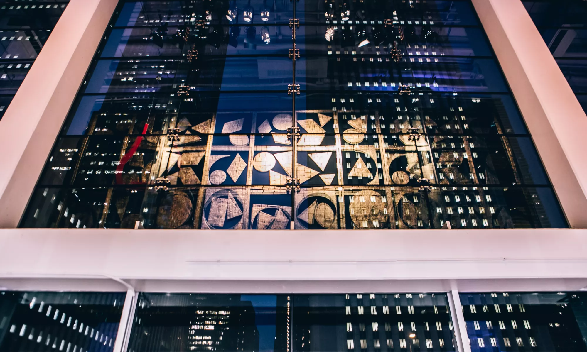 Image of Nevelson hanging artwork handing in the lobby of the Harris Theater with the reflection of Chicago high rise