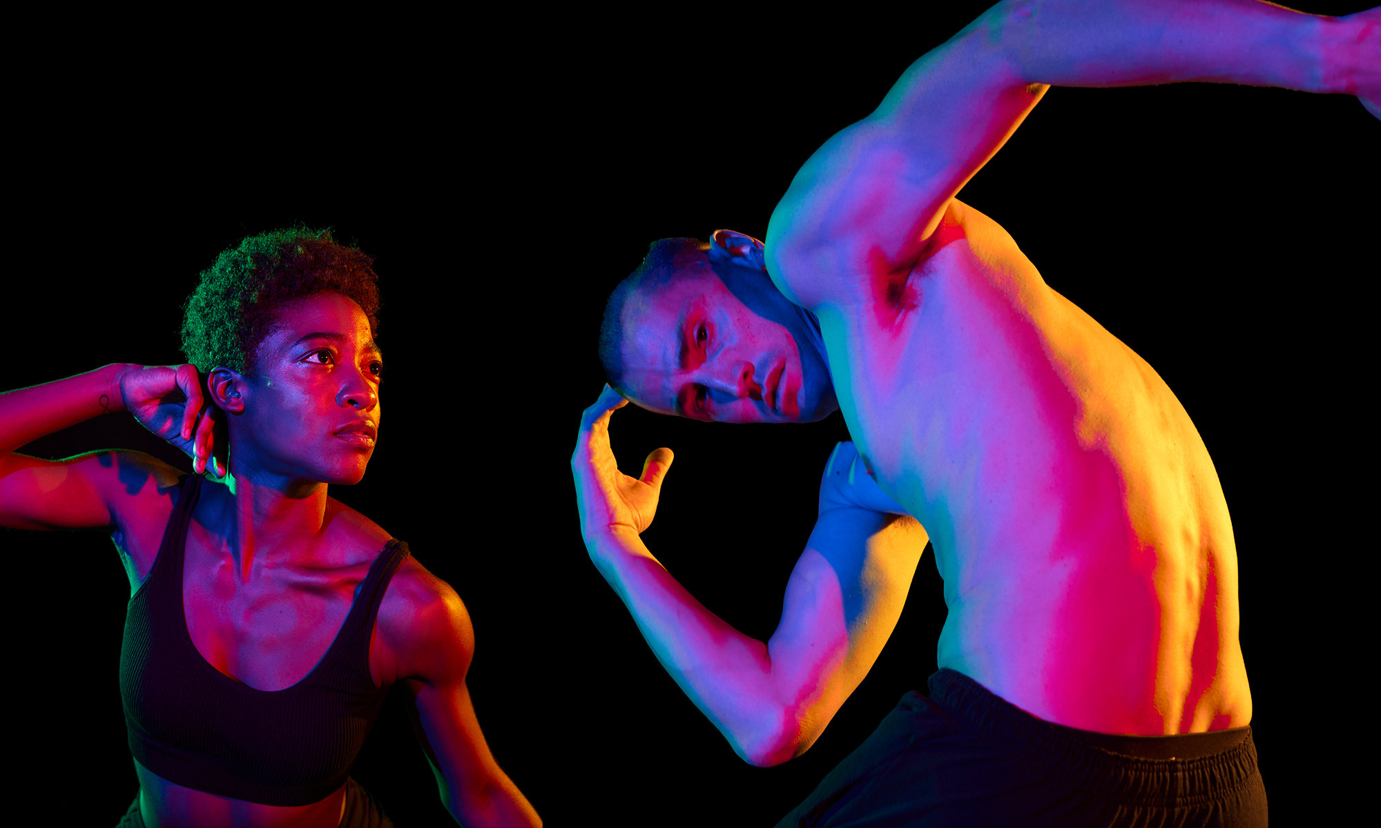 Two dancers from Hubbard Street Dance with a black background