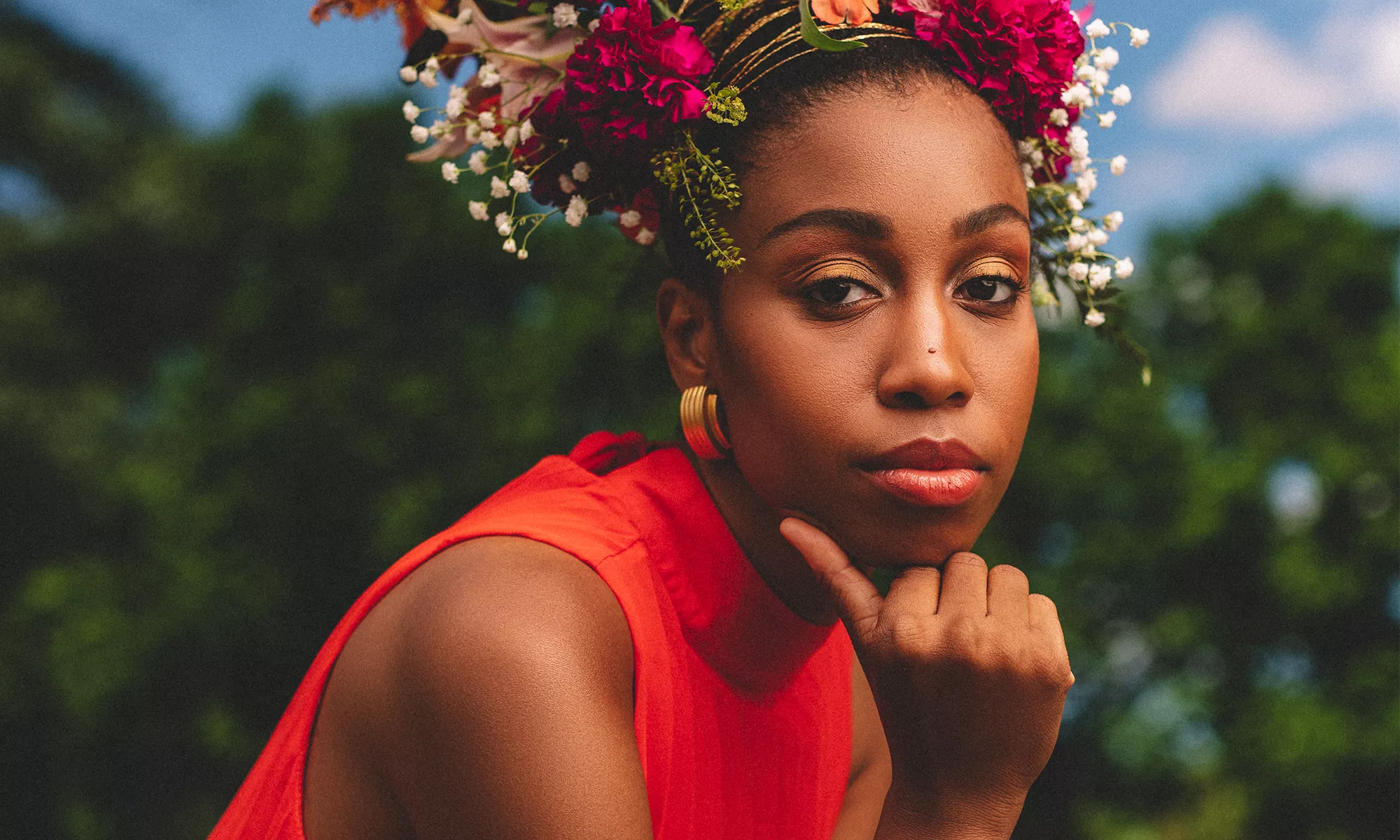 Jazzmeia Horn wears a bright orange top with a flower crown on her head