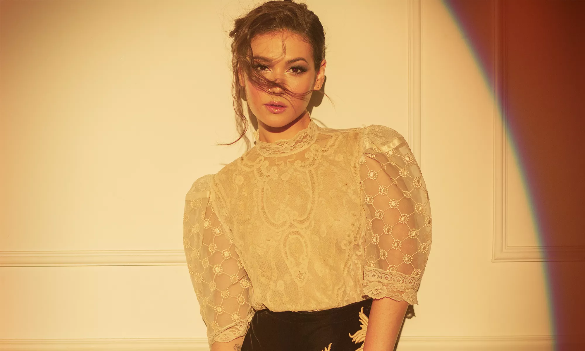 Nella wears a beige transparent blouse with black pants