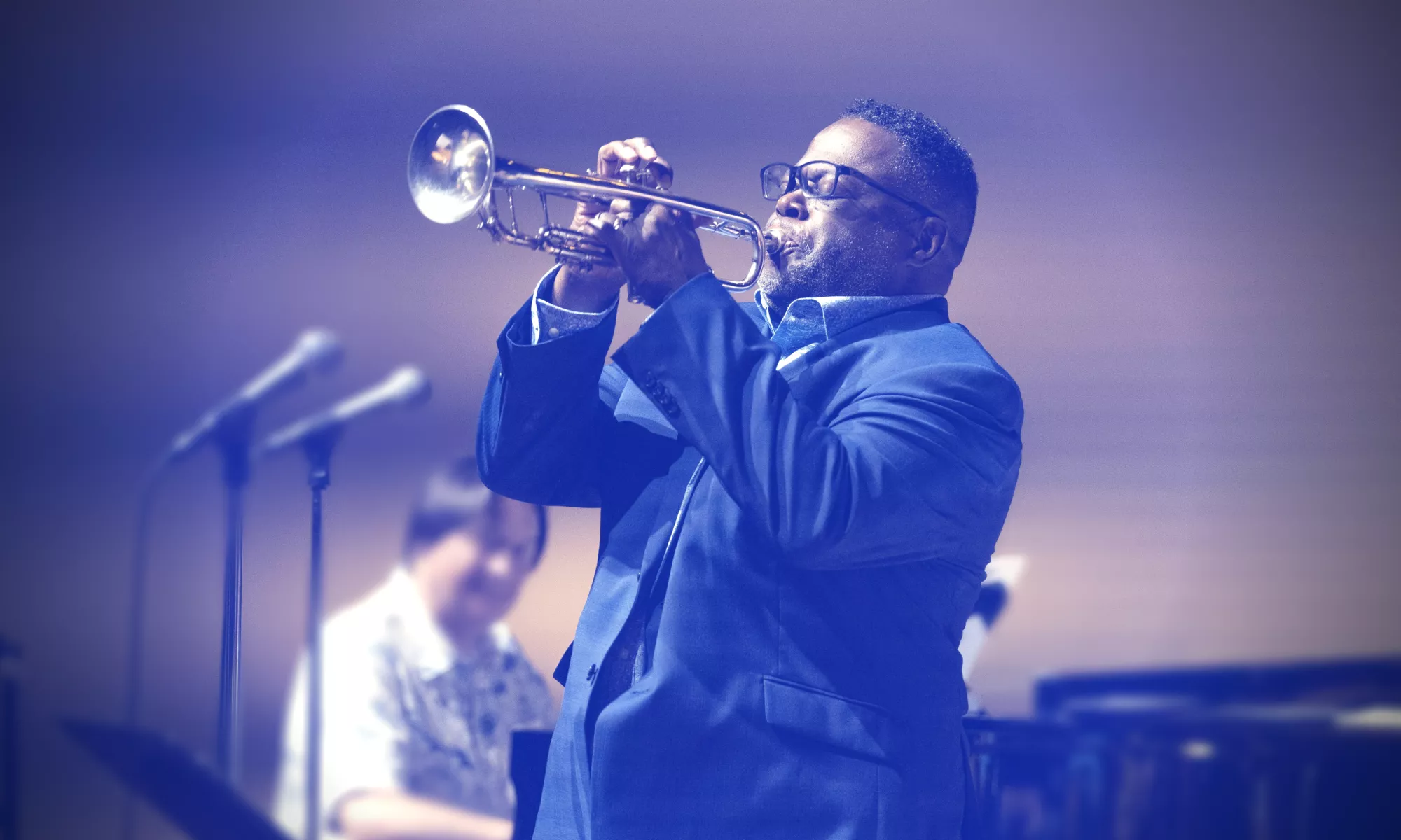 Musician wears a suit and plays the trumpet