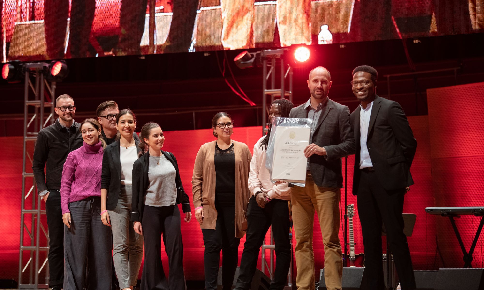 Image of a group of people on stage celebrating receiving their award.