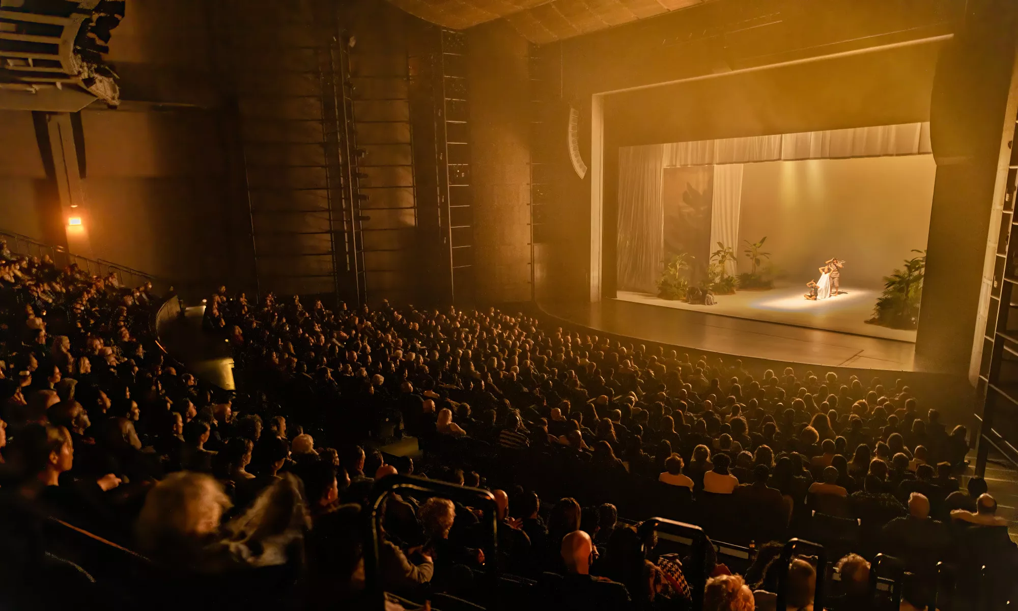 An image of a full house during a performance happening on the Harris Theater stage. 