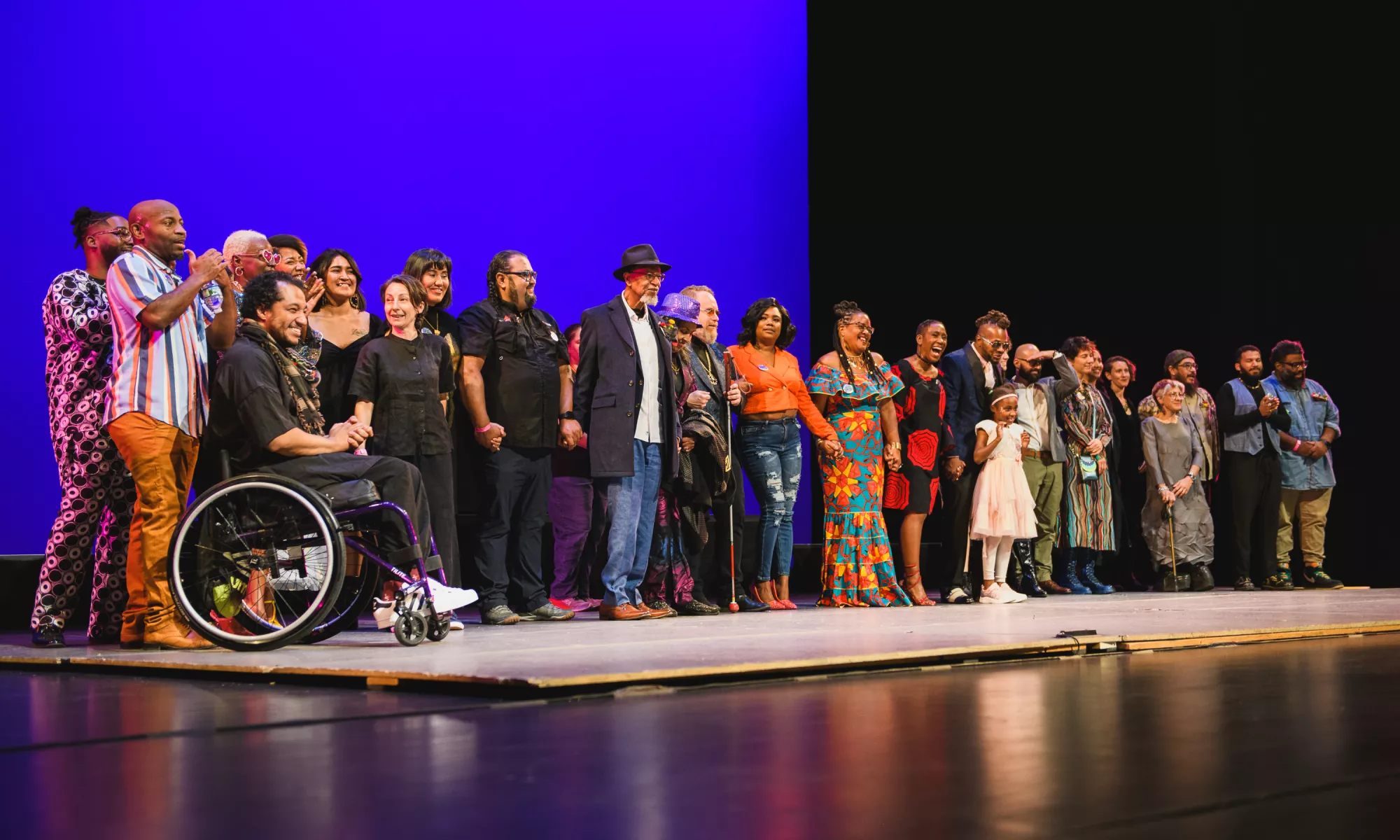 A large group of people on stage looking out to the audience.