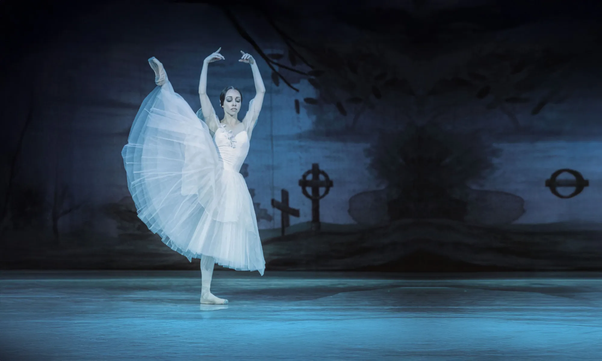 A ballerina pirouettes on a dark and gloomy stage.