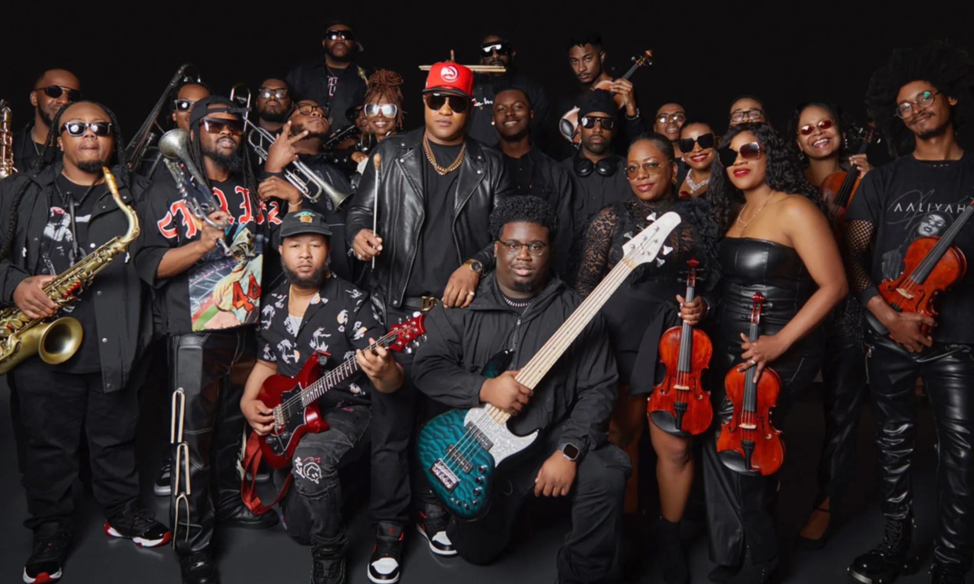 A large group of people posing together with their instruments.