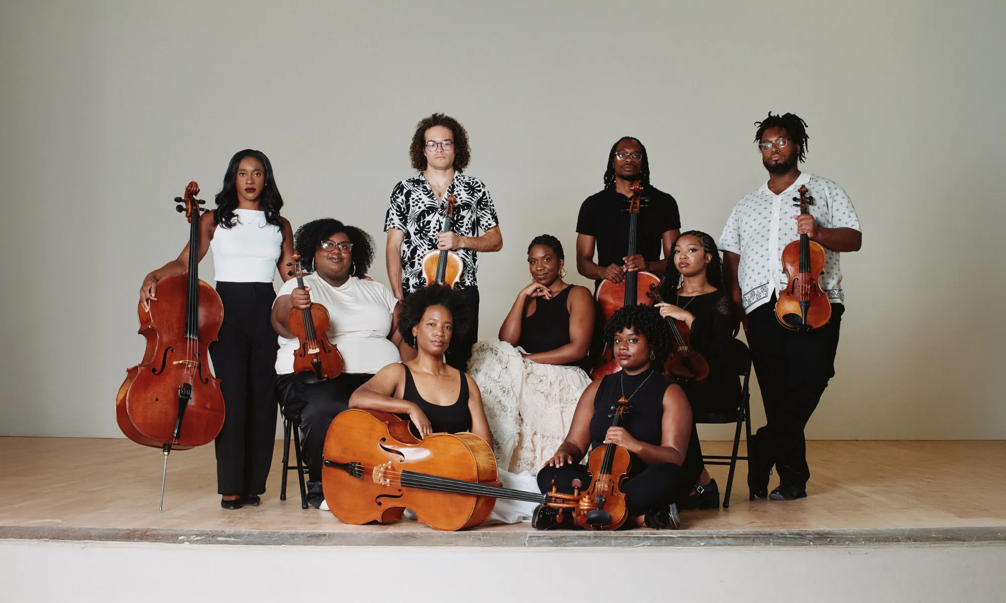 D-Composed posing on stage with their instruments.