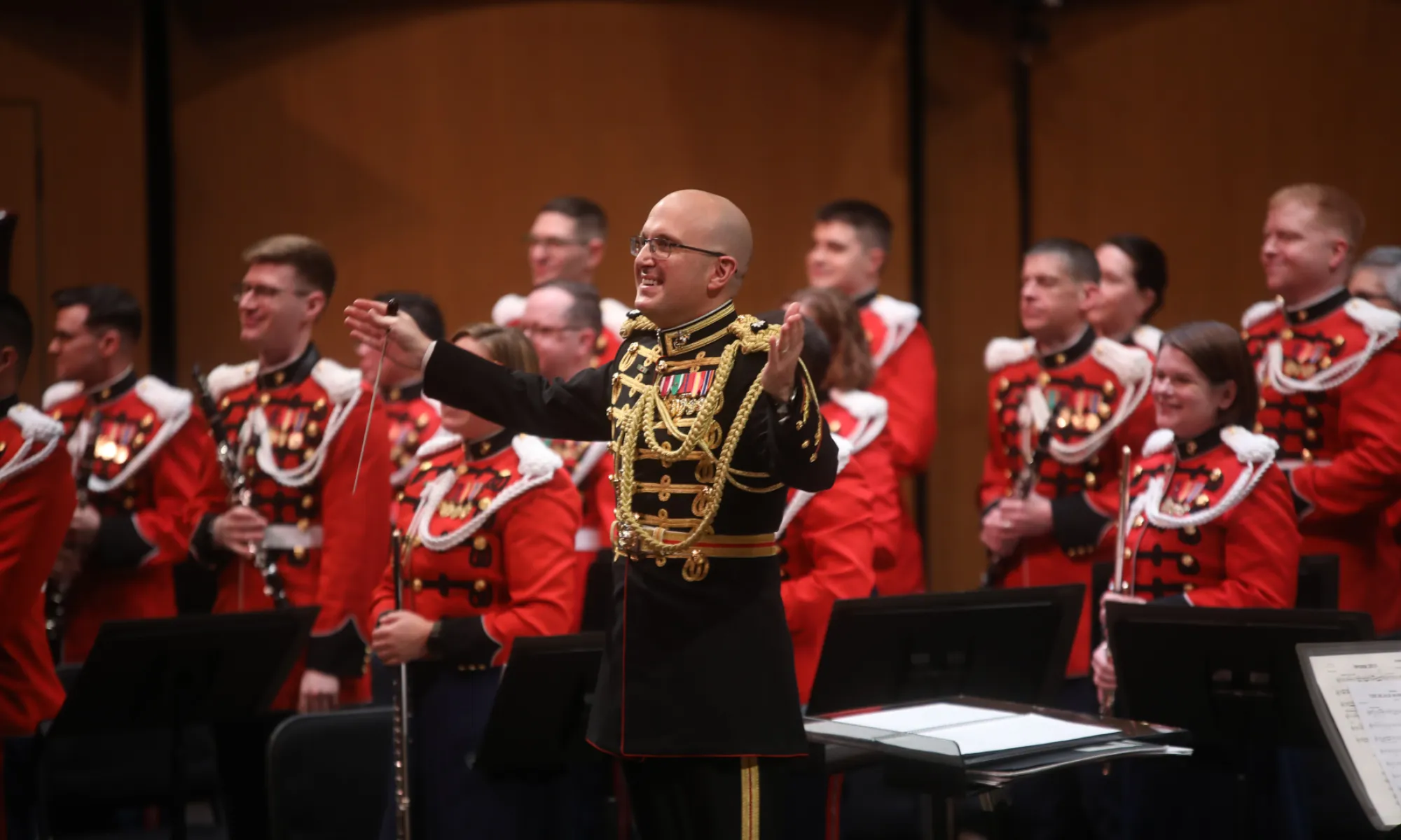 The US Marine band standing and smiling for an audience.