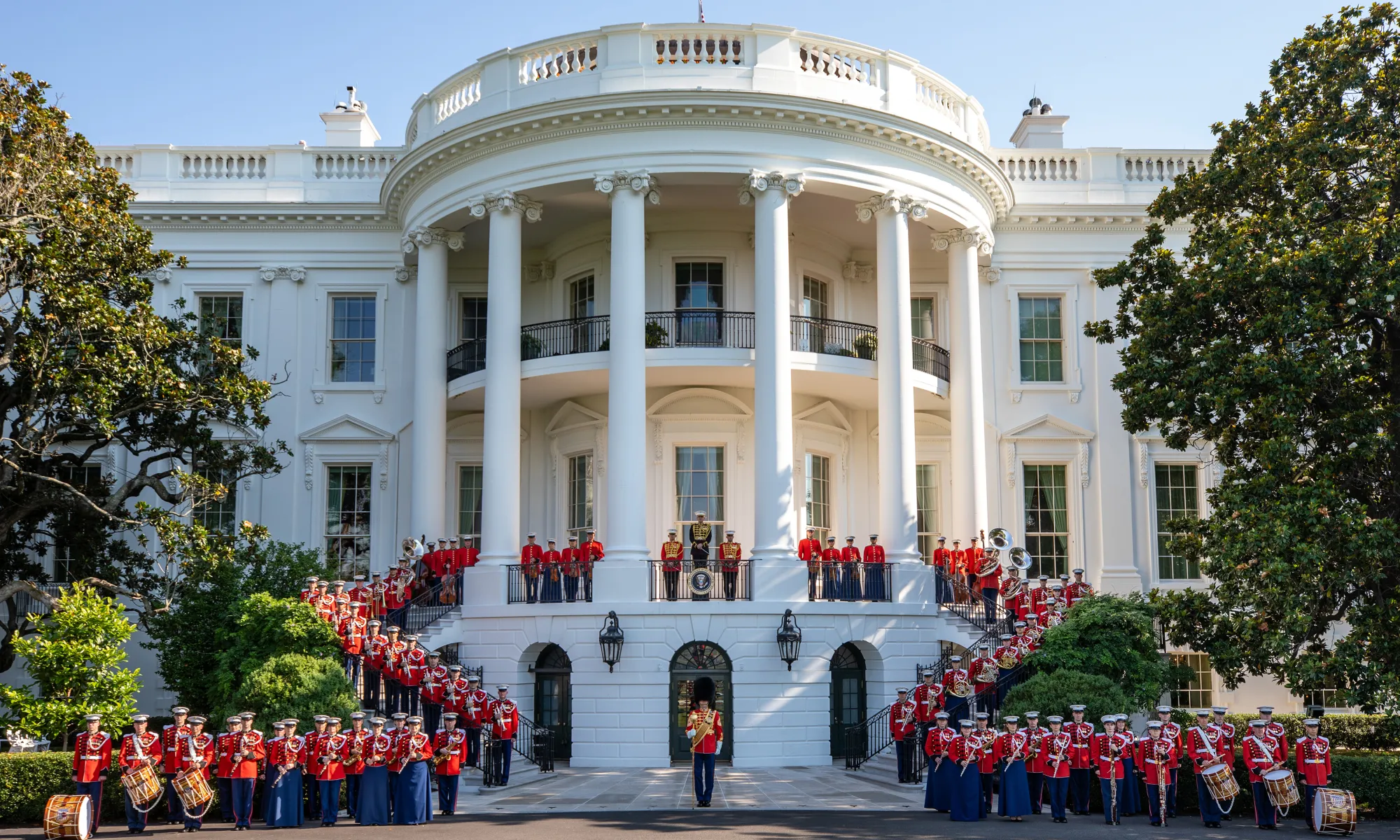The United States Marine Band posing in front of the White House.