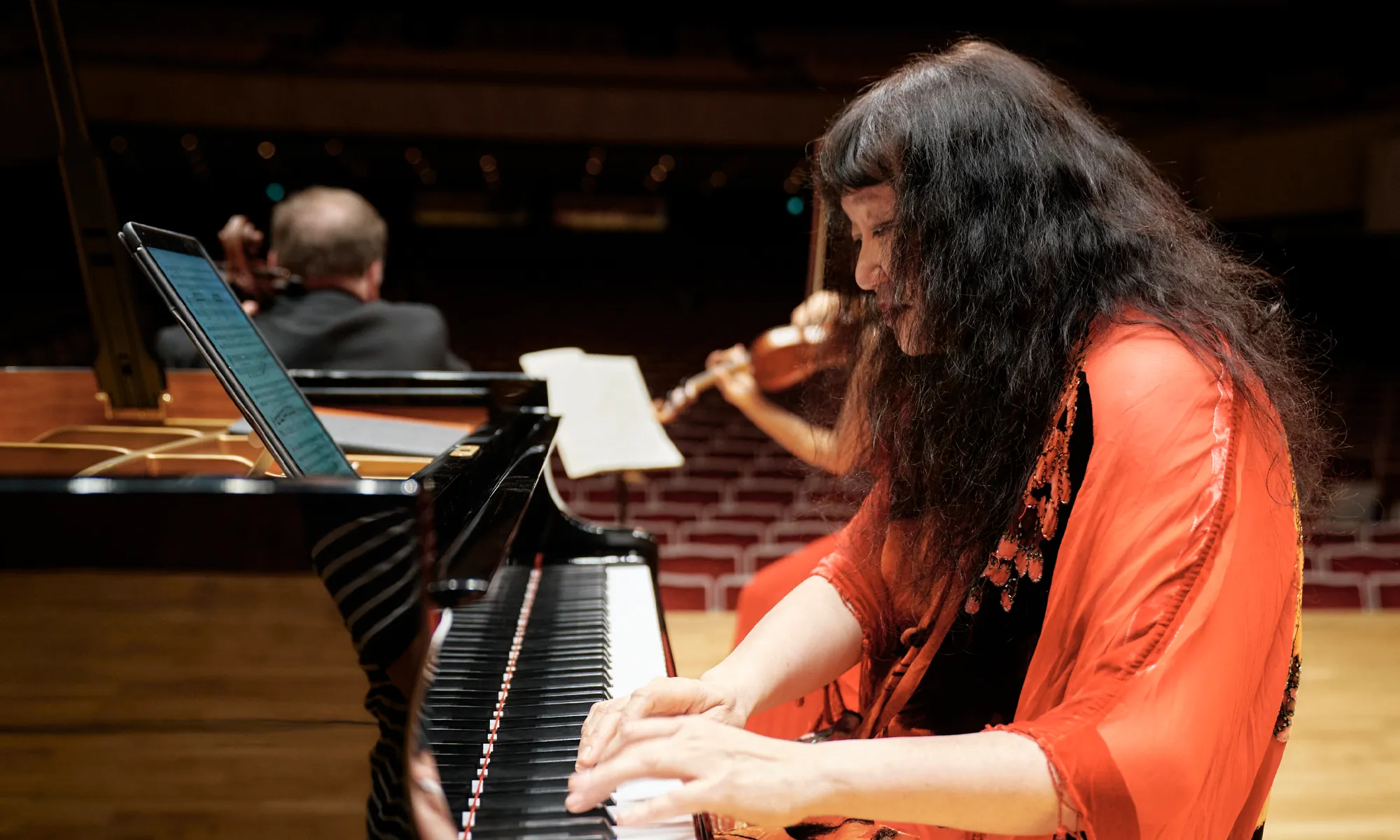 Wu Han playing the piano while other musicians play in the background