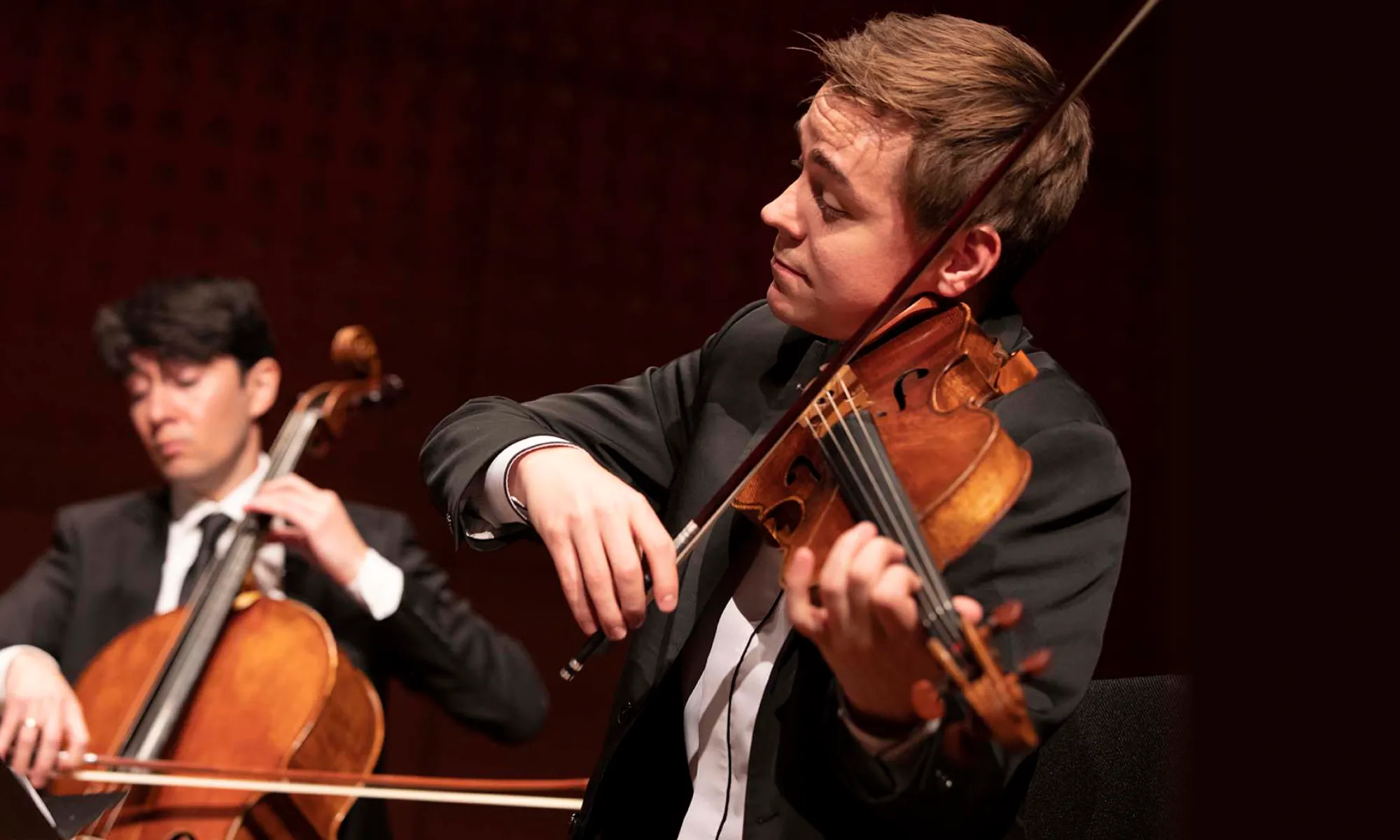 One man performs with the viola, while another plays the cello.