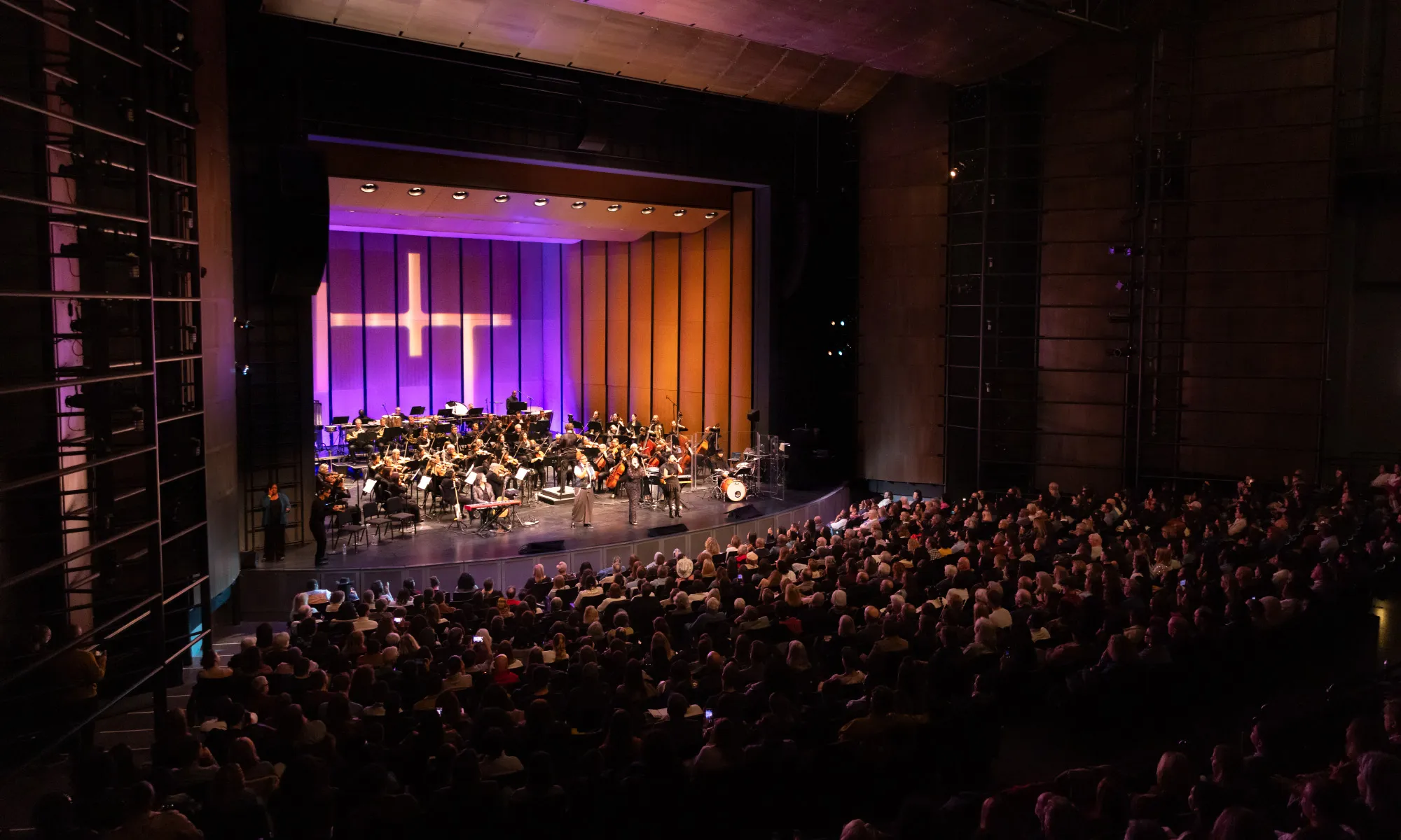 The Harris Theater auditorium packed. The audience watches a performance.