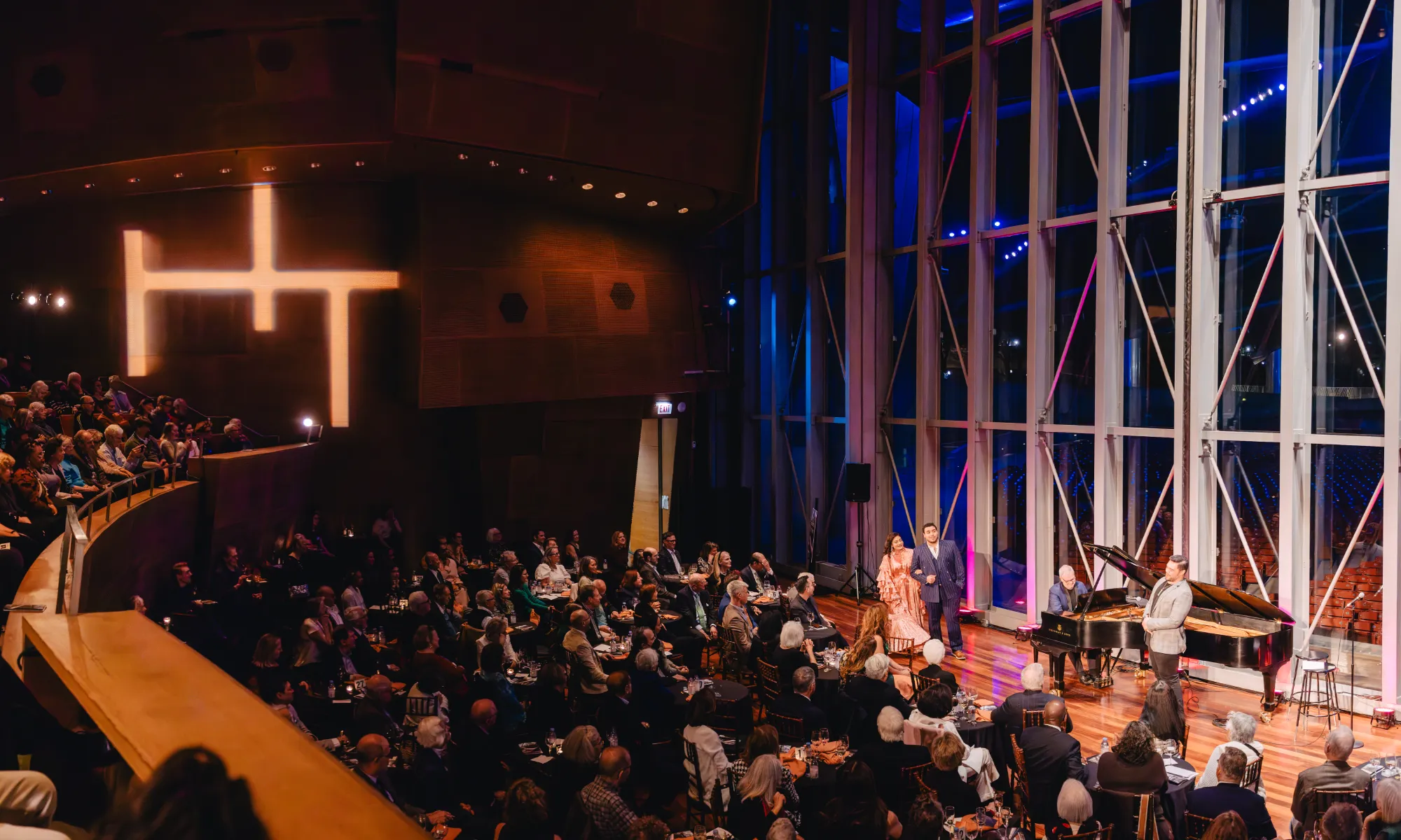 Artists performing on the Pritzker Pavilion stage at night.