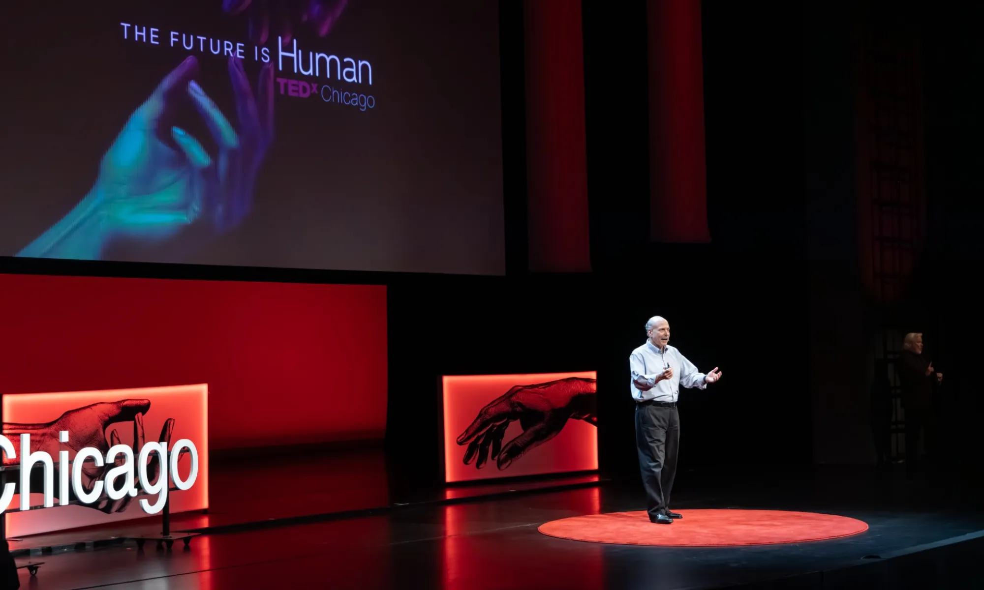 A man speaking on stage during the TEDX conference. 