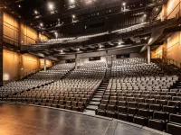Image of an empty auditorium. The shot is from the stage looking towards the seating. 