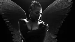 Soprano Measha Brueggergosman with her arms crossed across her chest with wings behind her