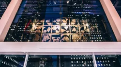 Image of Nevelson hanging artwork handing in the lobby of the Harris Theater with the reflection of Chicago high rise