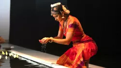 Ragamala Dance Comapany dancer kneeling and holding water in their hands