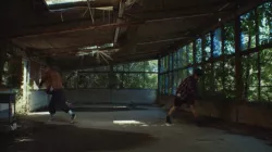 Two dancers standing opposite each other inside an empty building 