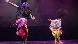 Two African American female dancers in motion. Arms spread apart hair  flowing. The dancers 