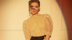 Nella wears a beige transparent blouse with black pants