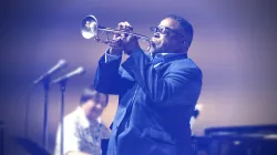 Musician wears a suit and plays the trumpet