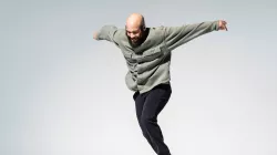 Jumanne mid-tap performance in front of a blank white backdrop.