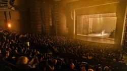 An image of a full house during a performance happening on the Harris Theater stage. 