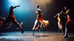 Performers on stilts running. 