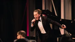 Ian Rucker singing into a microphone.