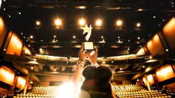 Award being proudly hoisted towards the bright lights of the Harris Theater.