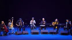 An ensemble of musicians on stage performing.
