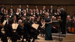 An opera singer performing with an orchestra.
