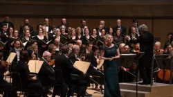 An orchestra and opera singer performing.
