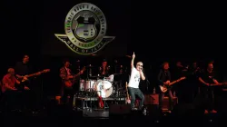 REO Speedwagon’s Kevin Cronin performs onstage with the band beneath the illuminated Illinois Rock & Roll Museum Hall of Fame logo during a live set.