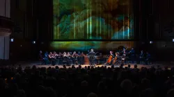 The Haymarket Opera Orchestra playing on stage in front of a full house.