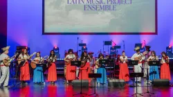 An ensemble of young musicians playing on the Harris stage. They all play the Cuatro guitar.