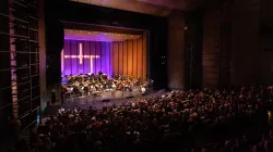 The Harris Theater auditorium packed. The audience watches a performance.