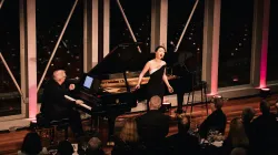 Ying Fang performing with Craig Terry in front of an audience. 